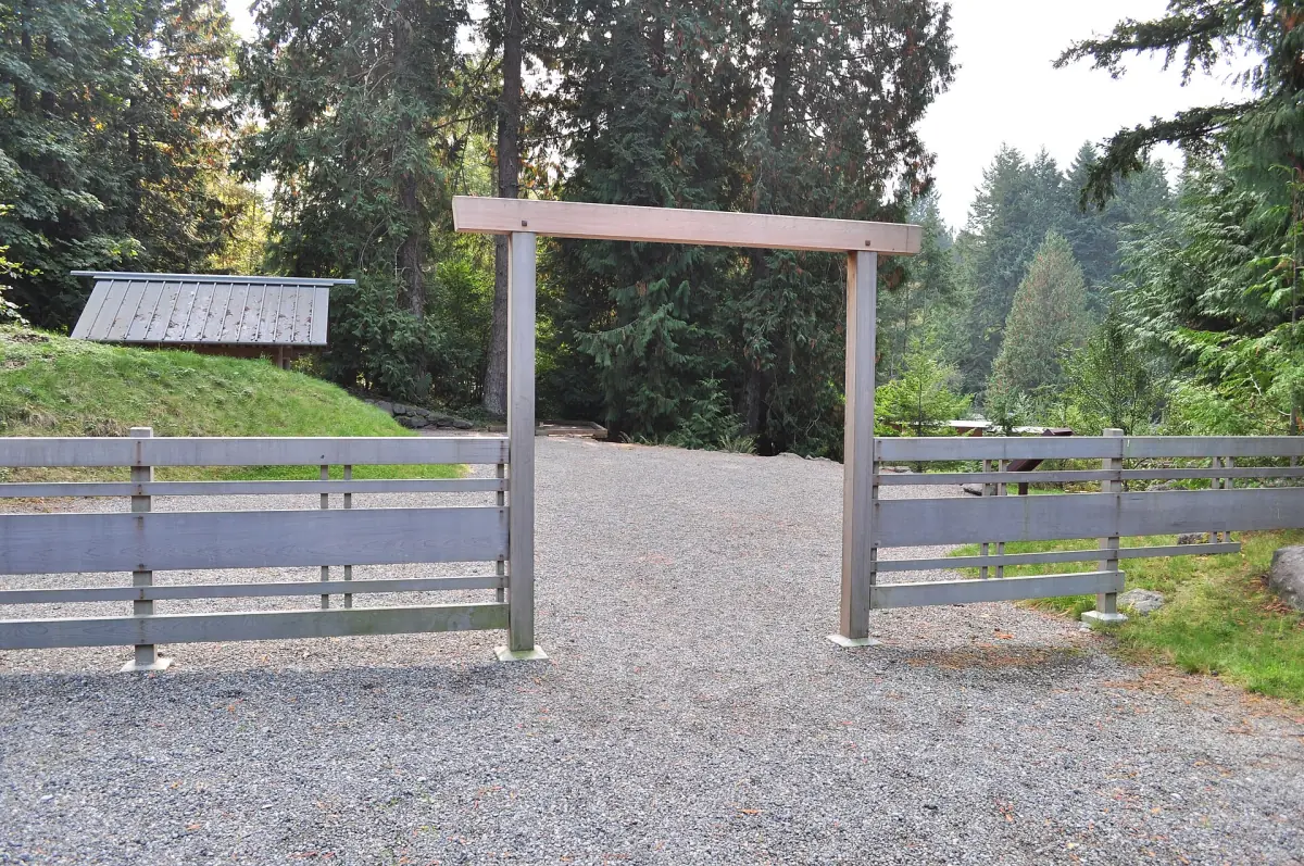 Wooden gate at the entrance to the memorial grounds among trees