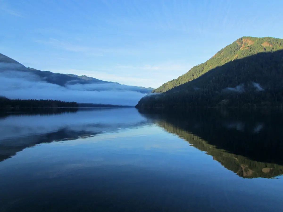 Mist over Lake Crescent with forested slopes in morning light
