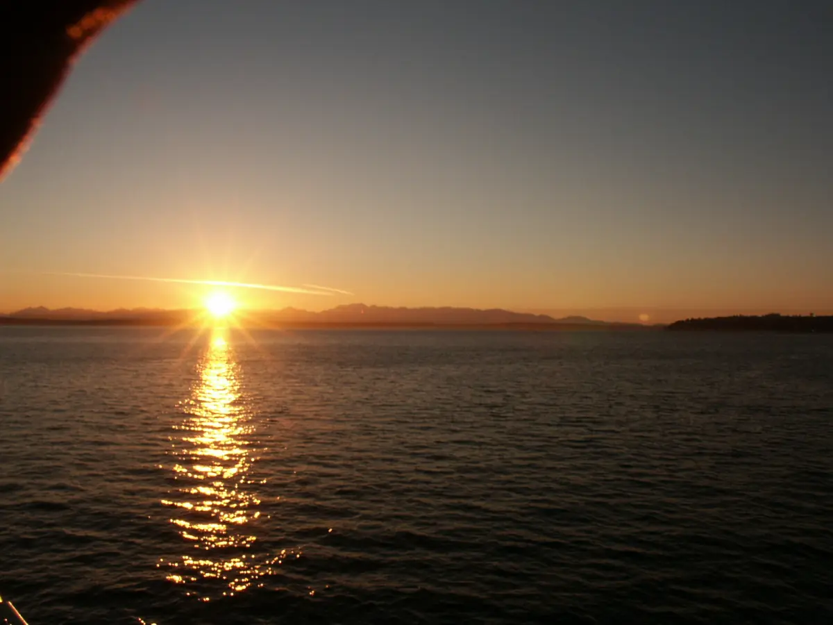 Sun setting over calm water with a reflected glow on Puget Sound
